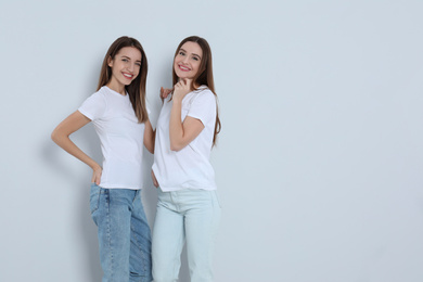 Photo of Young women in stylish jeans on light background. Space for text