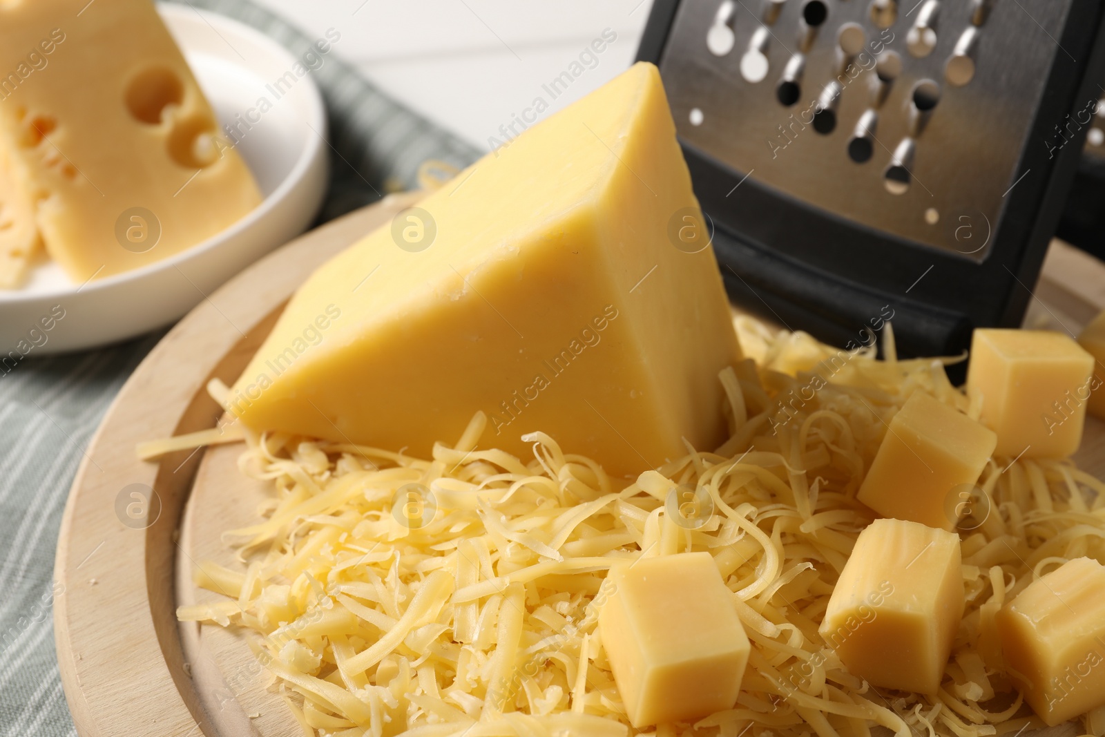 Photo of Grated and whole pieces of cheese on table, closeup