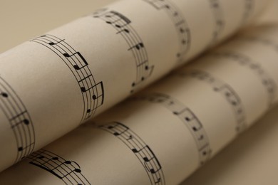 Rolled sheets with music notes on white background, closeup