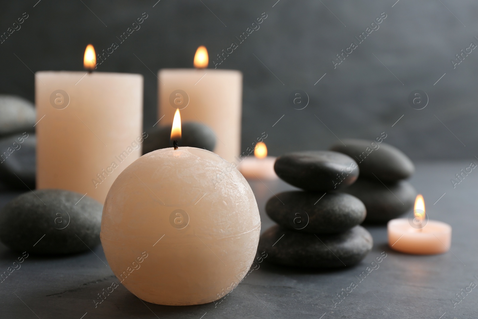 Photo of Beautiful composition with candles and spa stones on table