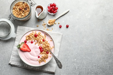 Photo of Bowl with yogurt, berries and granola on table, top view