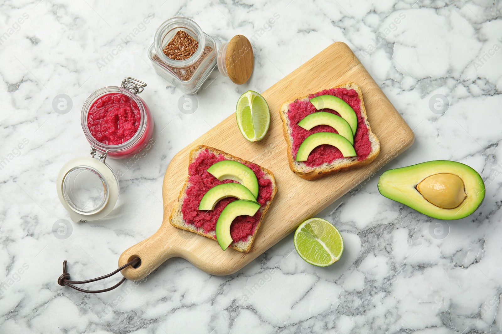 Photo of Tasty crisp toasts with avocado and chrain on wooden board, top view