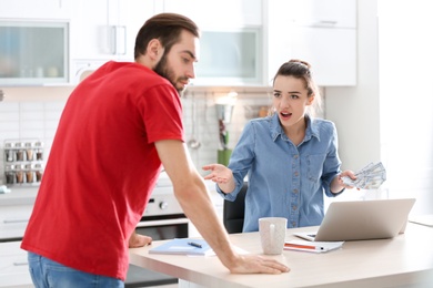 Young couple having argument about family budget in kitchen