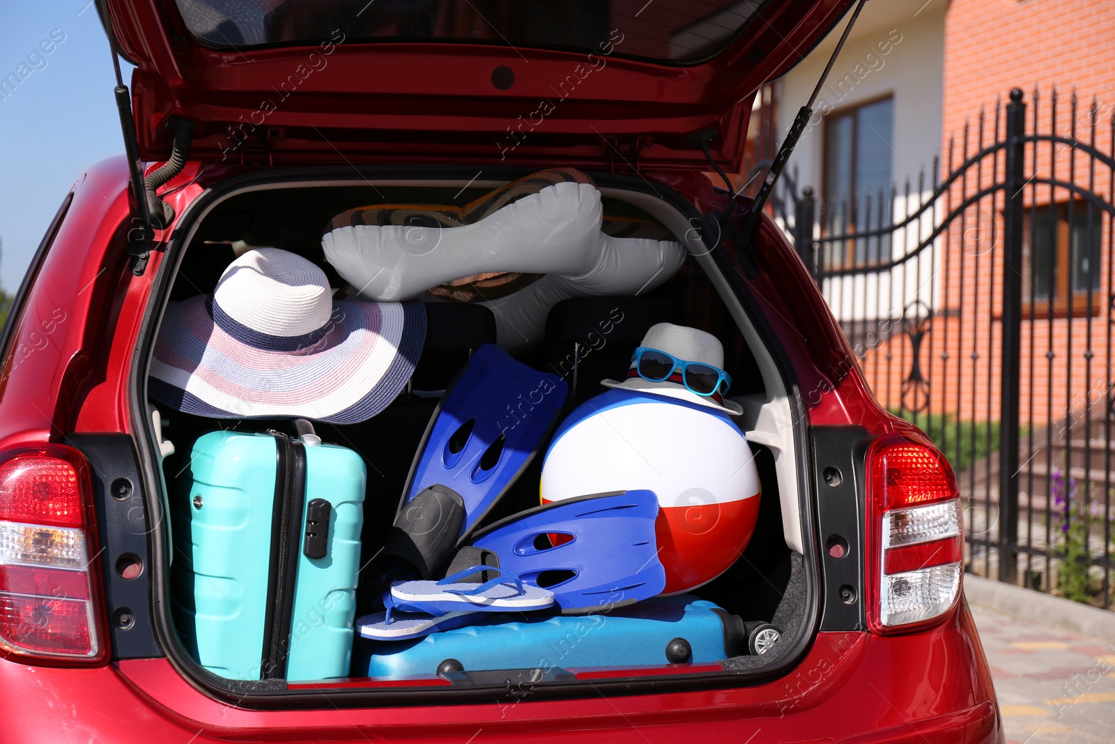 Photo of Family car with open trunk full of luggage outdoors, closeup