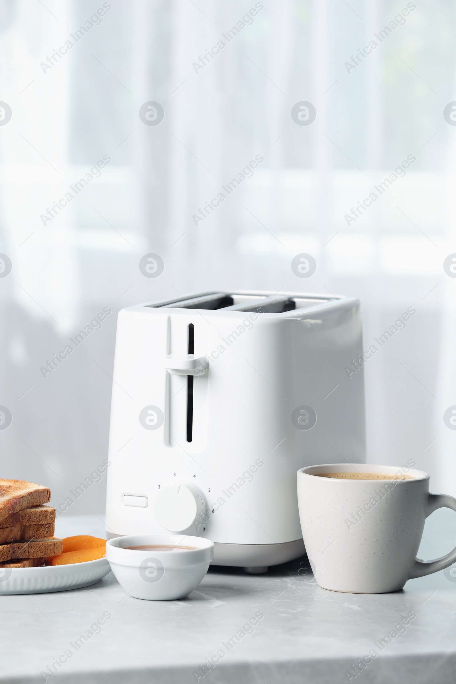 Photo of Toaster and tasty breakfast on light gray marble table