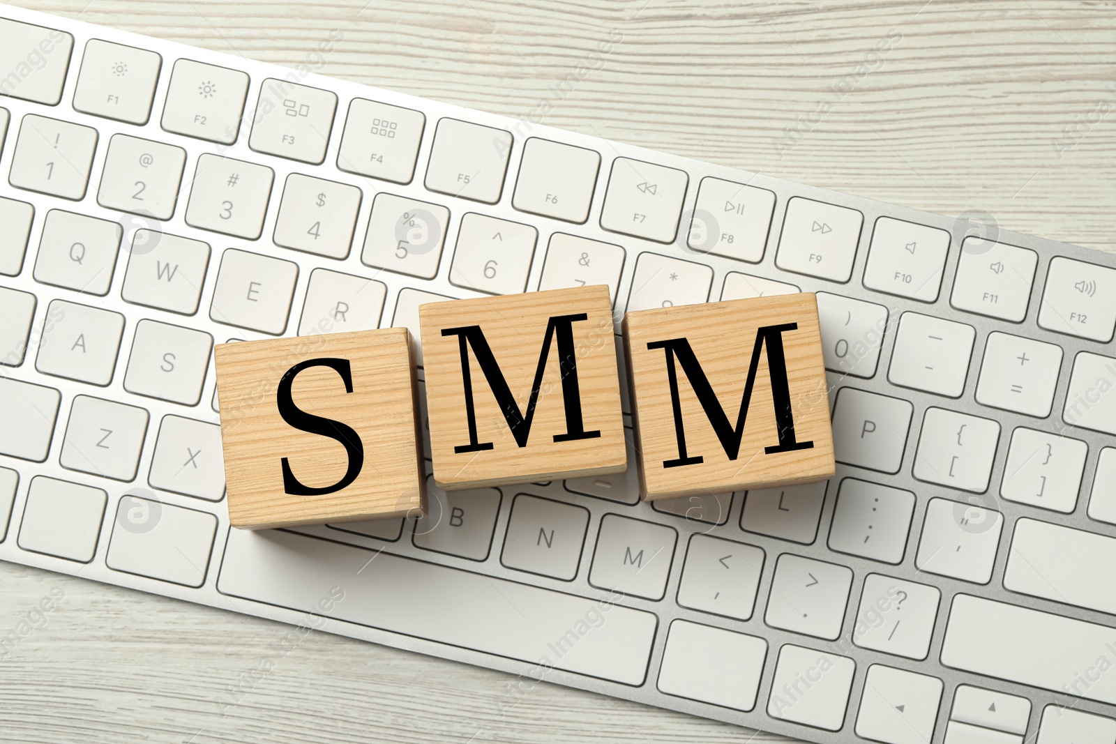 Photo of Empty wooden cubes on computer keyboard, top view. Space for design