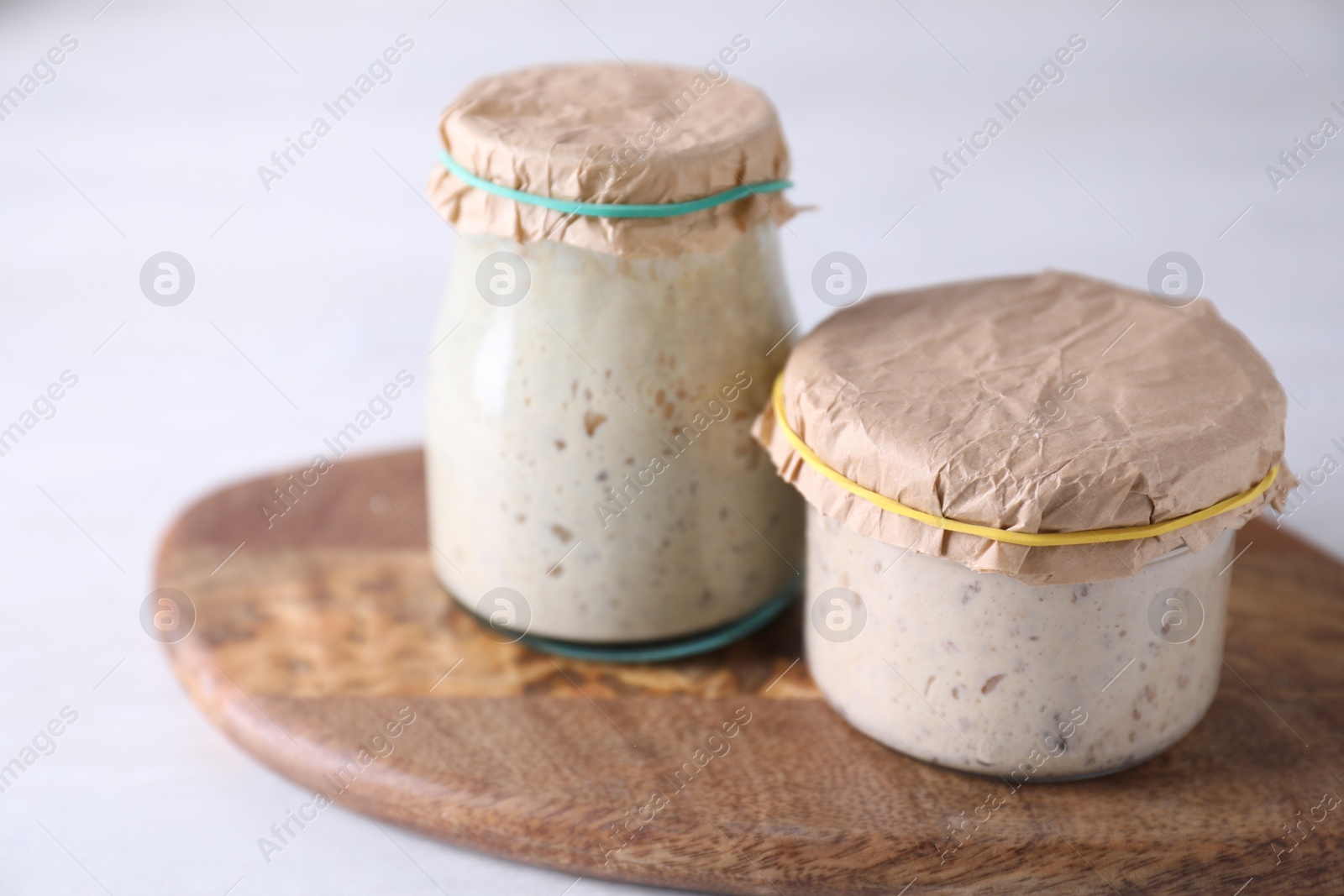 Photo of Sourdough starter in glass jars on light table, closeup