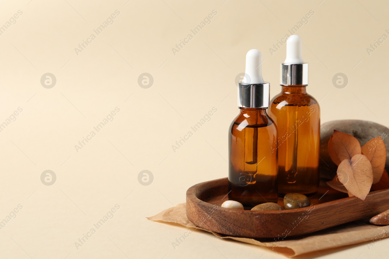 Photo of Composition with bottles of cosmetic serum on beige background. Space for text