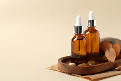 Photo of Composition with bottles of cosmetic serum on beige background. Space for text