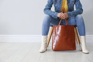 Woman in stylish leather shoes with bag indoors, closeup. Space for text