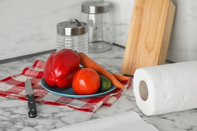 Different towels and fresh vegetables on marble table