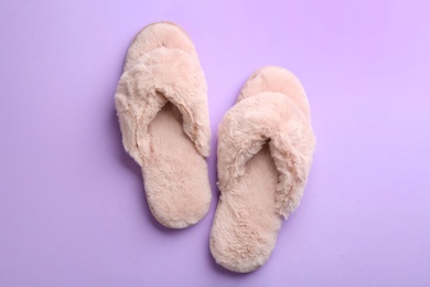 Pair of stylish soft slippers on violet background, flat lay