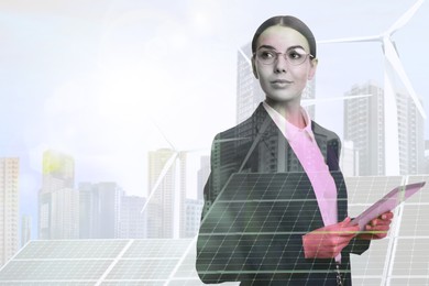 Multiple exposure of businesswoman with tablet, wind turbines and solar panels installed outdoors. Alternative energy source