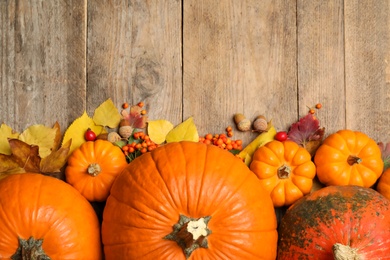 Photo of Flat lay composition with pumpkins and autumn leaves on wooden table. Space for text