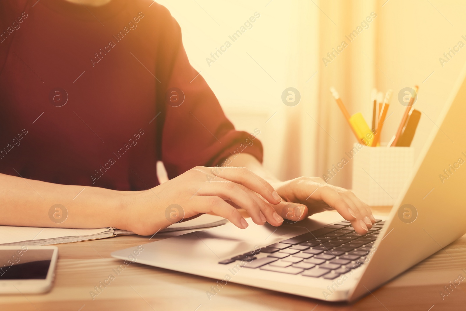 Image of Woman working with laptop at table indoors, closeup