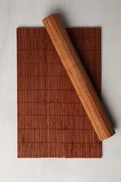 Photo of Bamboo mats on beige table, top view. Space for text