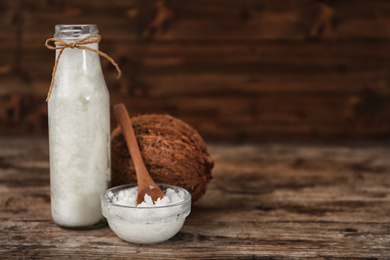 Photo of Fresh coconut oil on wooden table, space for text. Cooking ingredient