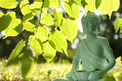 Photo of Decorative Buddha statue under tree branch outdoors