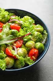 Photo of Bowl of salad with Brussels sprouts on table, closeup