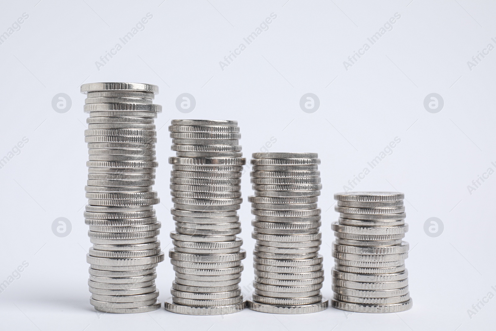 Photo of Many silver coins stacked on white background