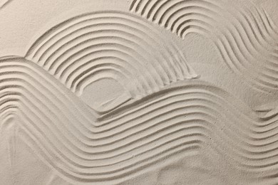 Photo of Beautiful patterns on sand, top view. Zen garden