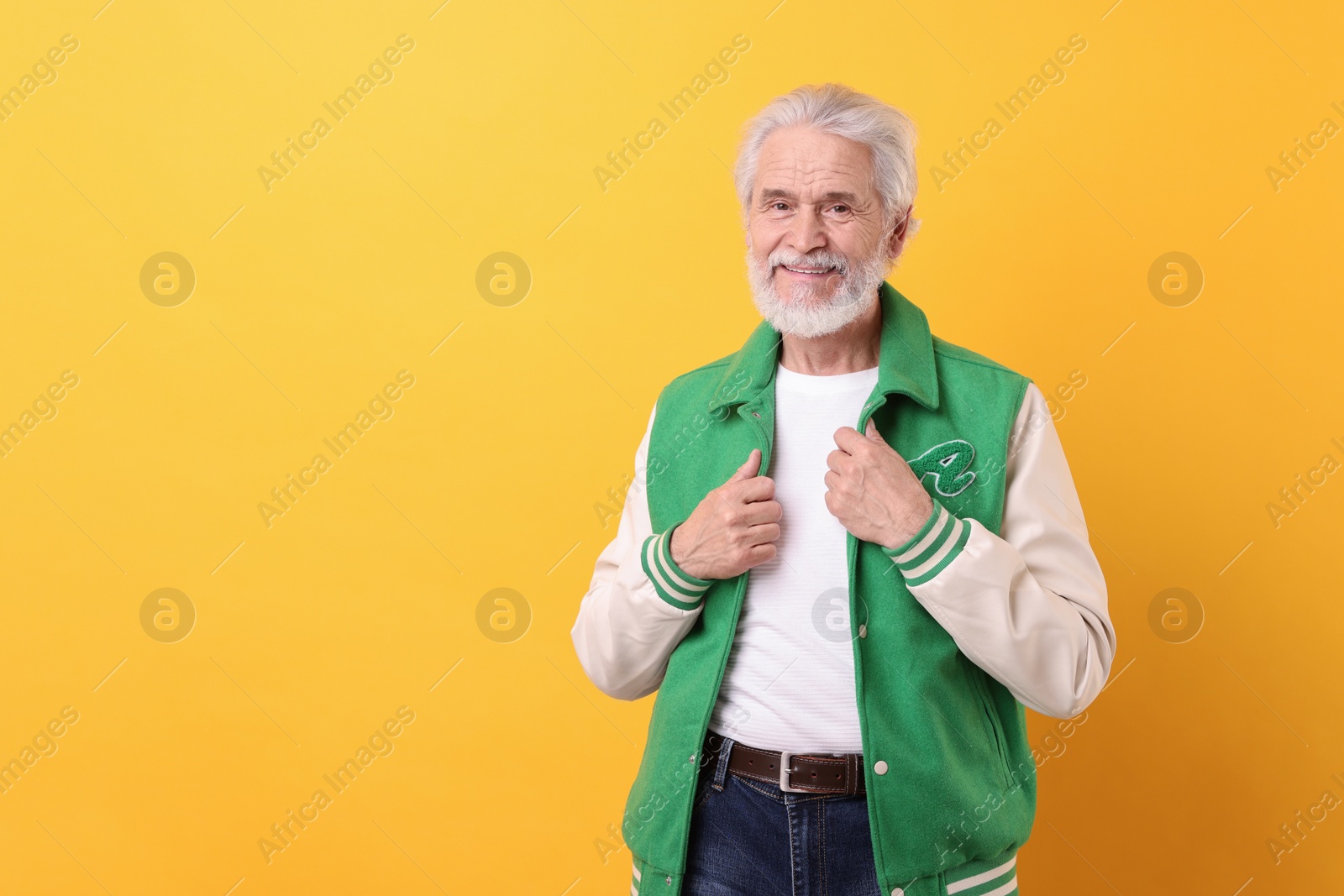 Photo of Portrait of stylish grandpa on yellow background, space for text