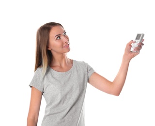 Photo of Young woman with air conditioner remote on white background