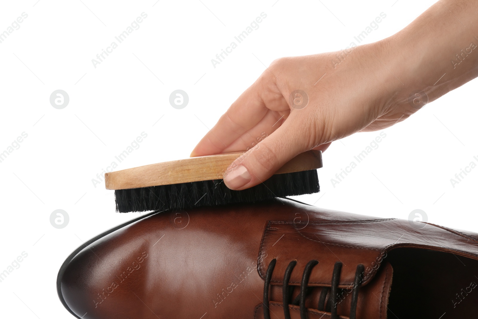 Photo of Woman cleaning stylish footwear on white background, closeup. Shoe care accessories