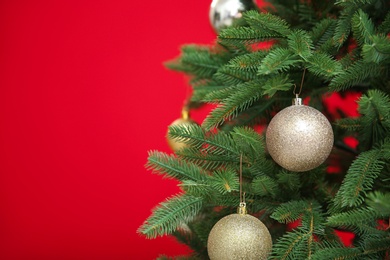 Beautifully decorated Christmas tree against color background, closeup