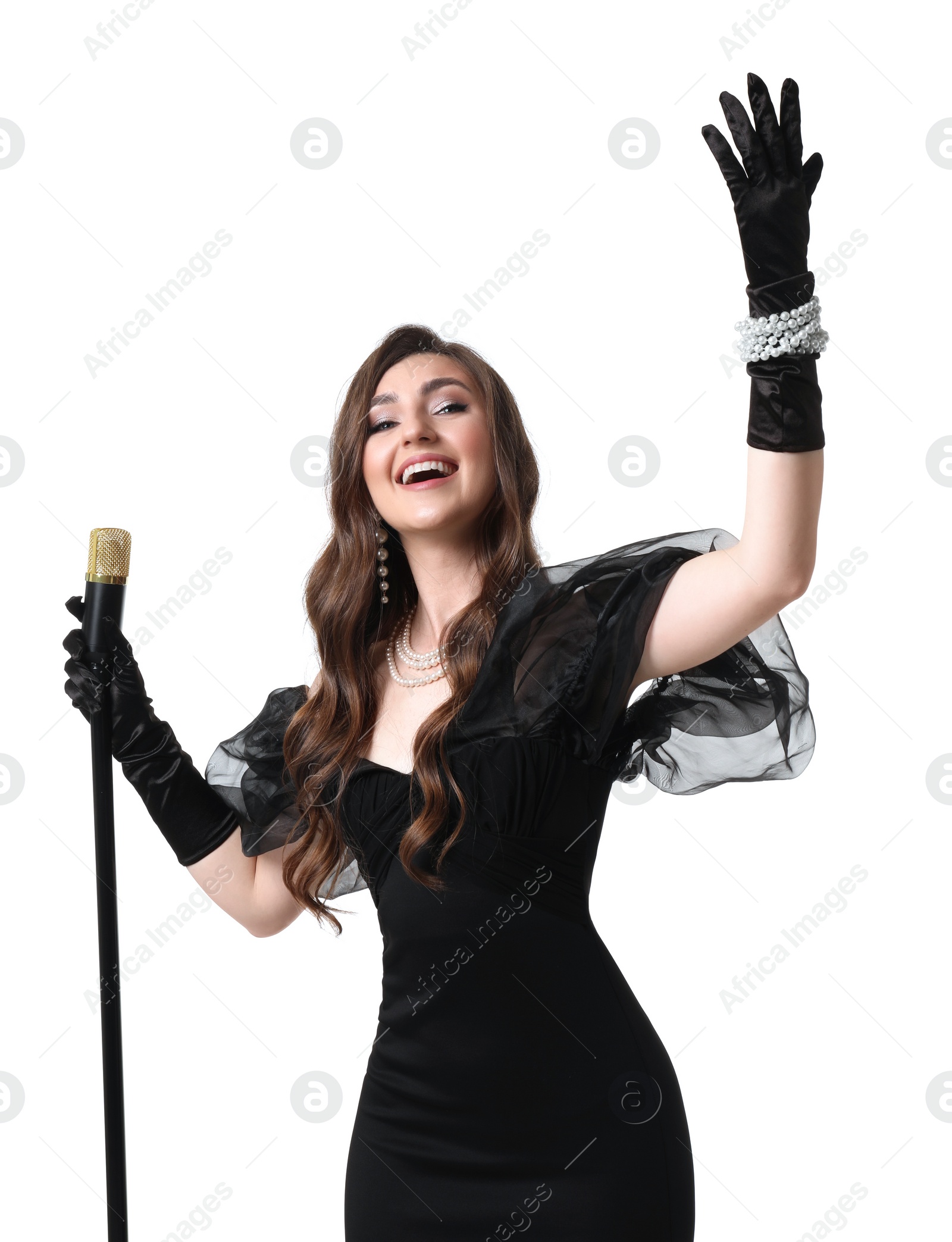 Photo of Beautiful young woman in stylish black dress with microphone singing on white background