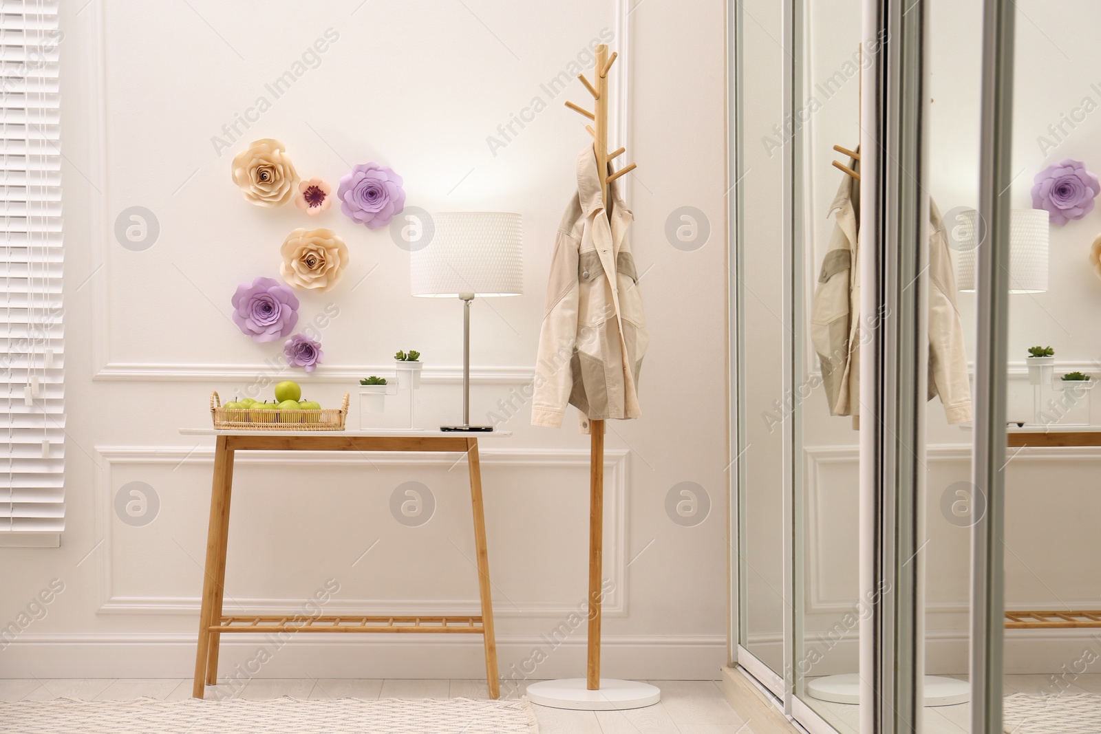 Photo of Stylish room interior with floral decor and table near wardrobe