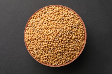 Photo of Bowl with mustard seeds on grey background, top view