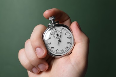 Photo of Man holding vintage timer on green background, closeup