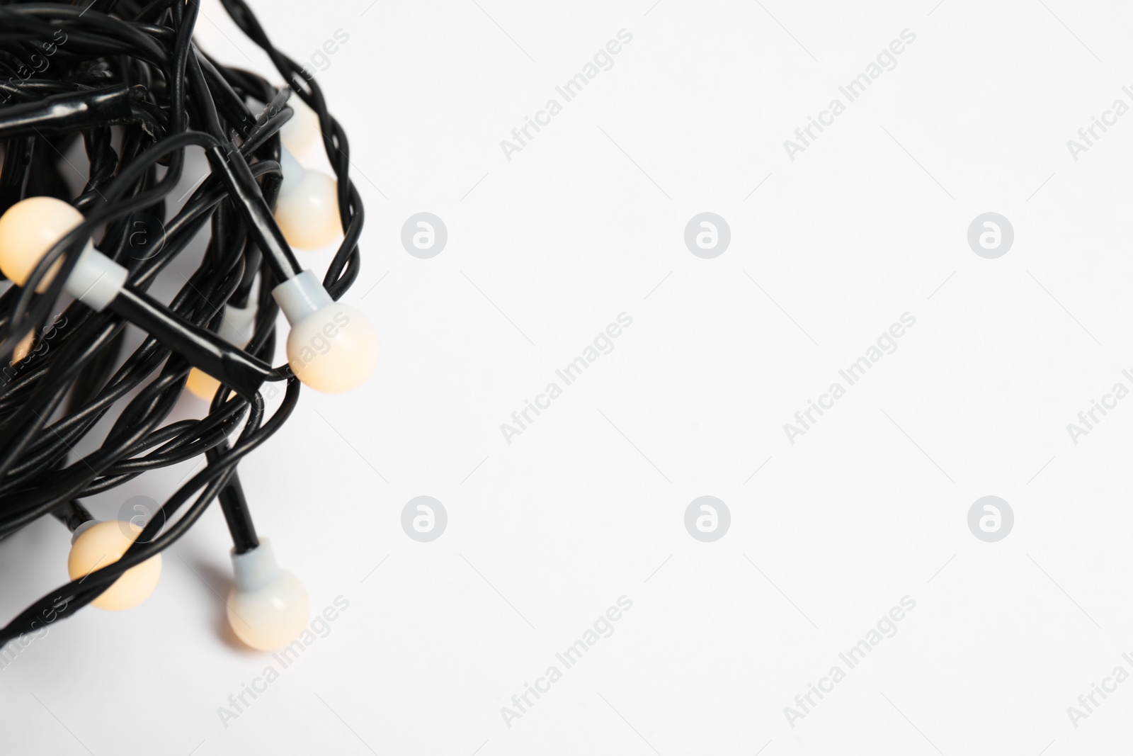 Photo of Beautiful Christmas lights on white background, closeup