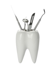 Photo of Tooth shaped holder with set of dentist's tools on white background