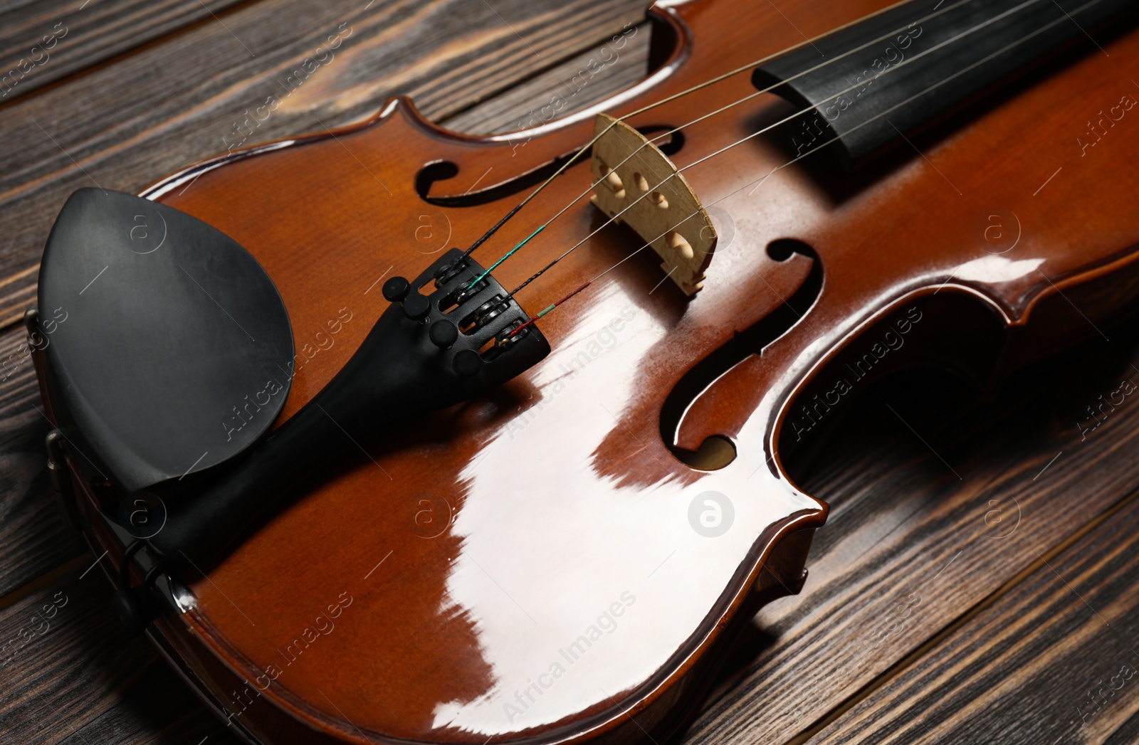 Photo of Classic violin on wooden background, closeup view