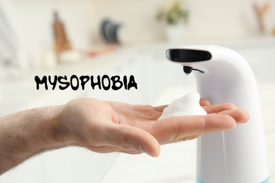 Image of Man using automatic soap dispenser indoors, closeup. Mysophobia
