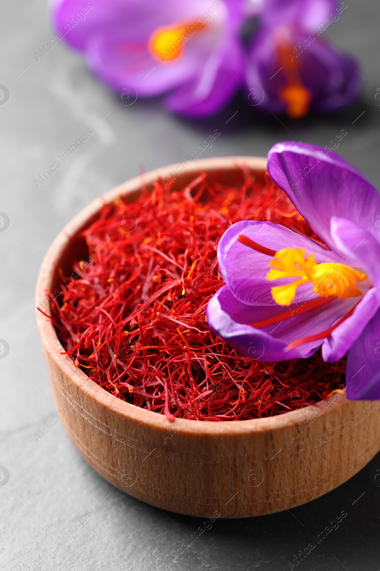 Photo of Dried saffron and crocus flower on grey table, closeup