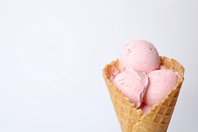 Delicious ice cream in waffle cone on white background