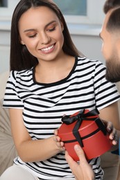 Photo of Woman receiving gift from her boyfriend at home