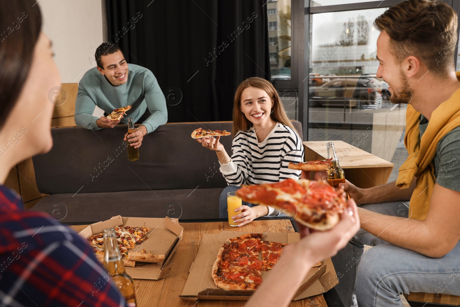 Photo of Group of friends having fun party with delicious pizza in cafe