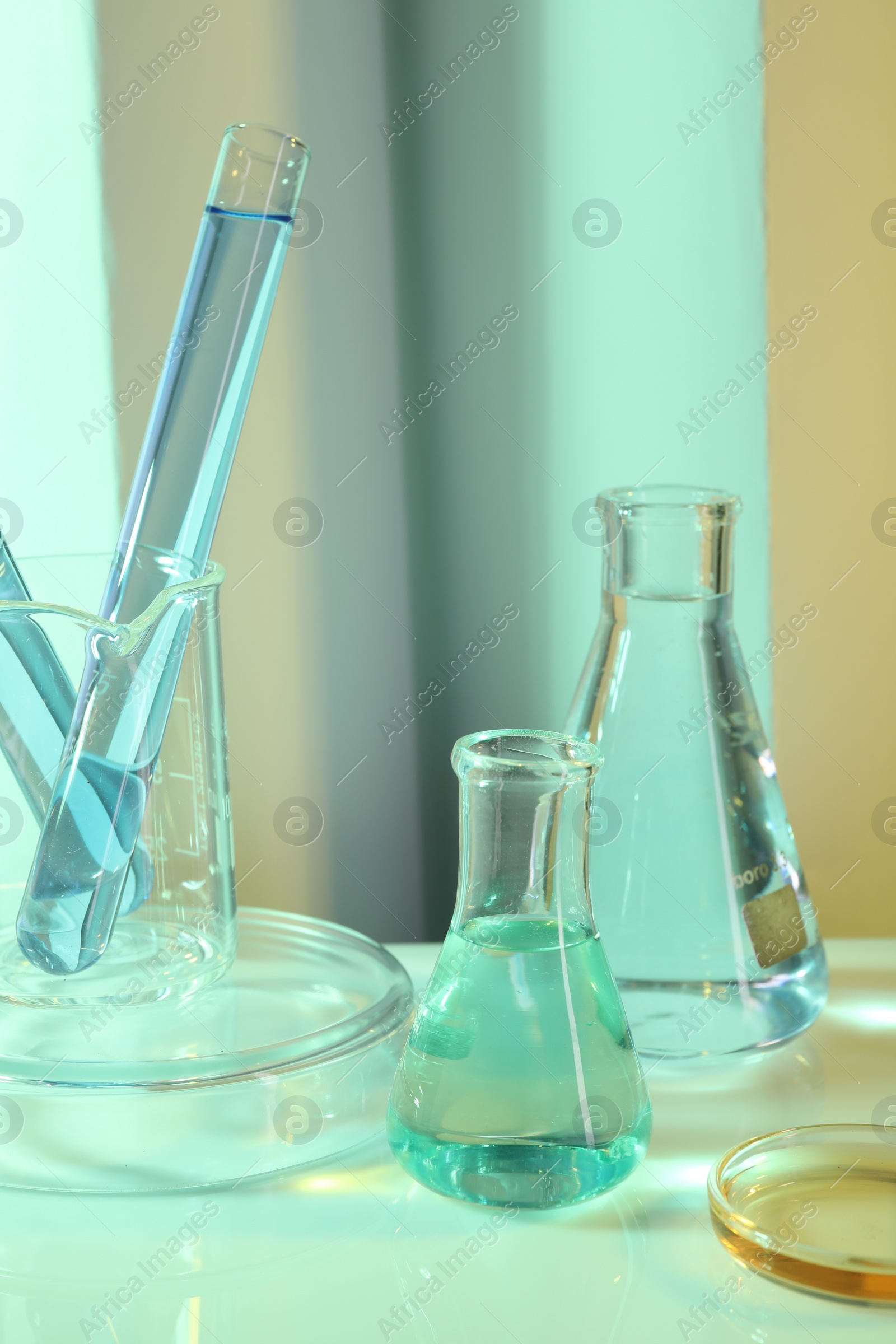 Photo of Laboratory analysis. Different glassware on table against color background