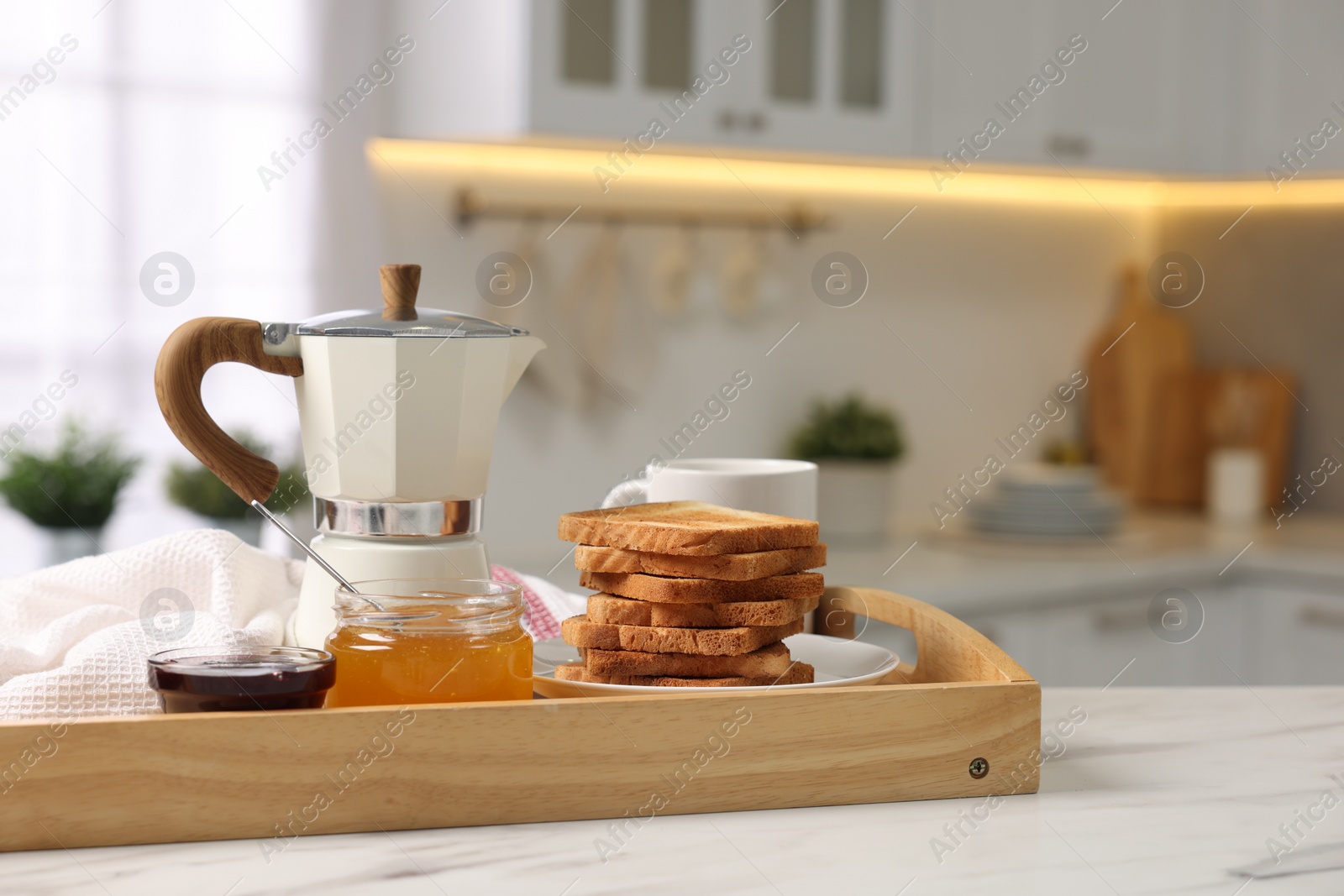 Photo of Breakfast served in kitchen. Tray with toasts, honey, jam and coffee on white table. Space for text