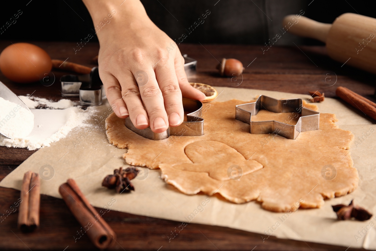 Photo of Woman making Christmas cookies at wooden table, closeup