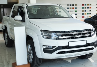 New luxury white car in modern auto dealership