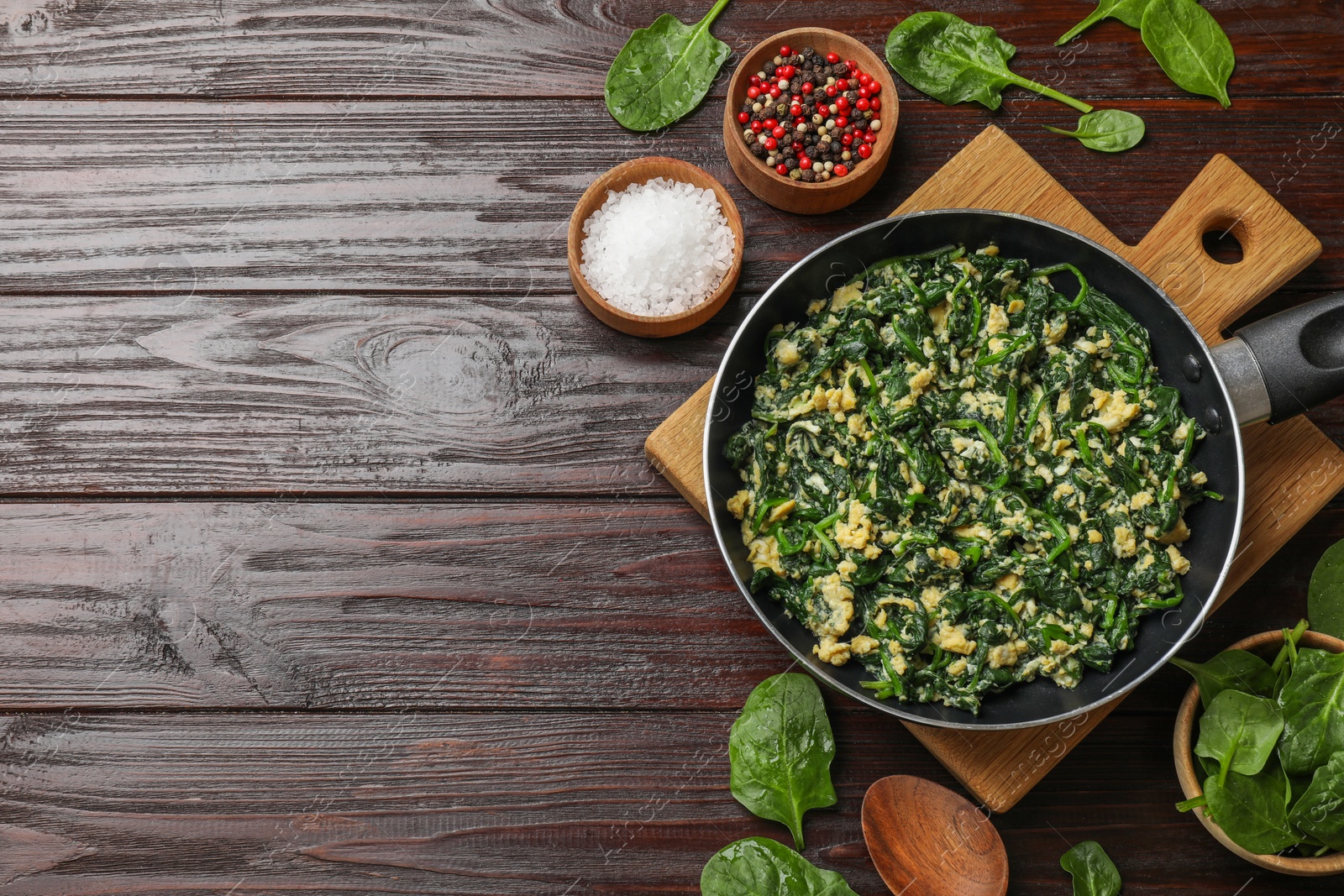 Photo of Tasty spinach dip with eggs in dish served on wooden table, flat lay. Space for text