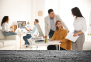 Image of Empty stone surface and blurred view of professional interior designers working in office, closeup. Space for text 