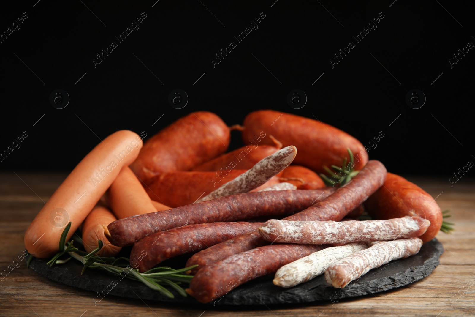 Photo of Different tasty sausages served on wooden table