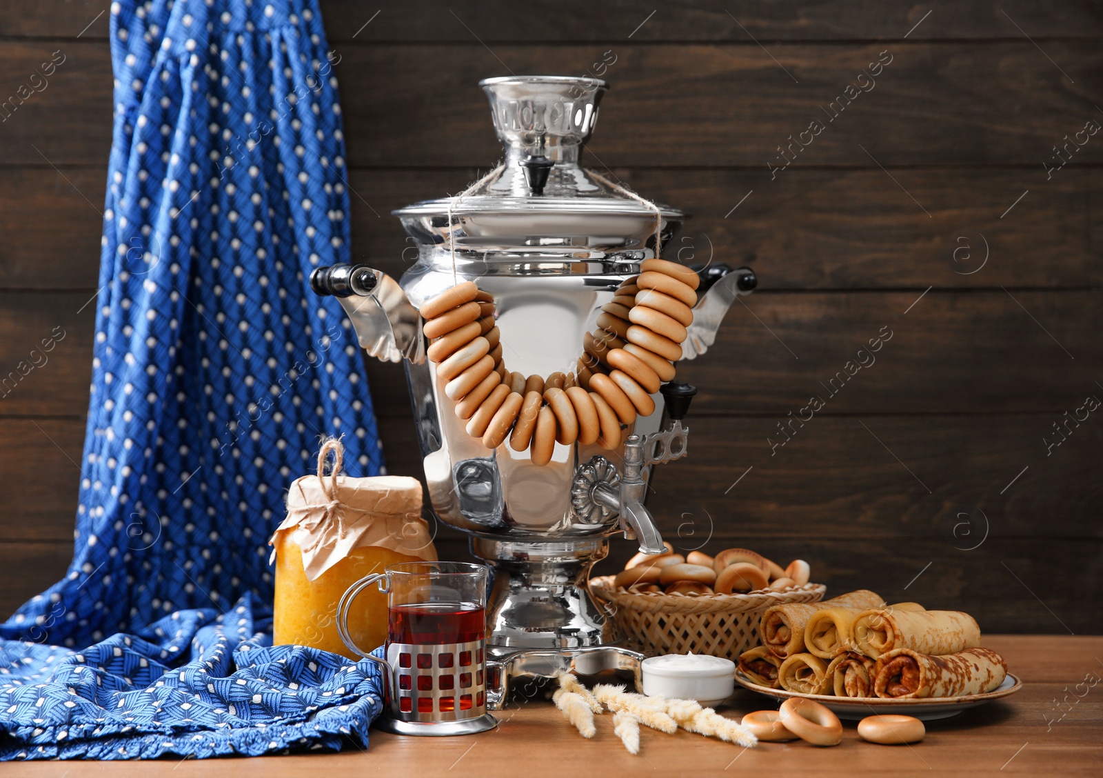 Photo of Traditional Russian samovar and treats on wooden table