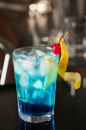 Photo of Blue Lagoon cocktail on black table in bar